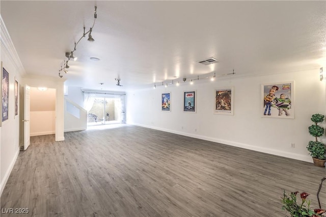 unfurnished living room with wood-type flooring, rail lighting, and ornamental molding