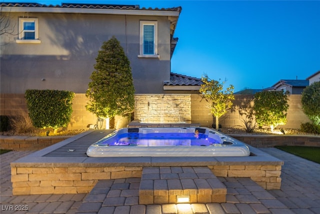 view of swimming pool featuring fence and an in ground hot tub