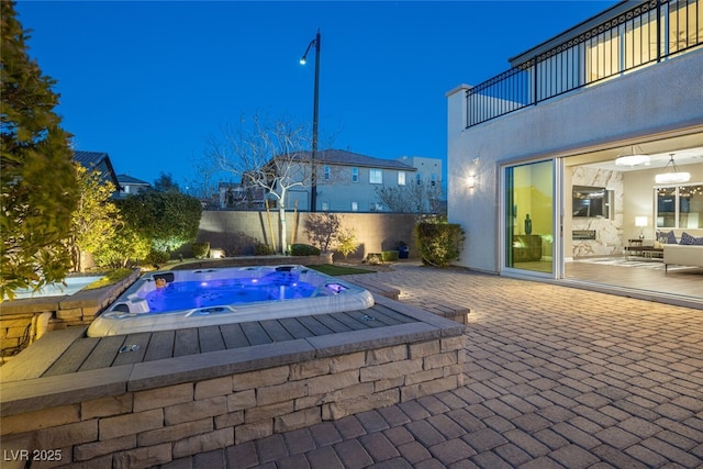 view of swimming pool featuring a patio area, fence, and an in ground hot tub