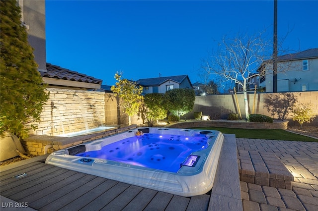 view of pool with hot tub deck surround, a deck, and a fenced backyard