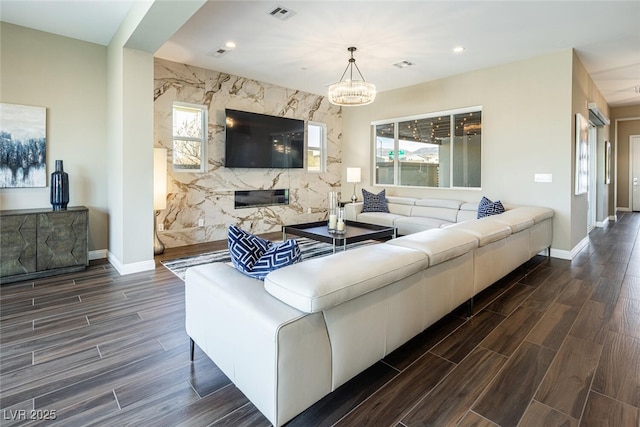 living room featuring wood finish floors, visible vents, and baseboards