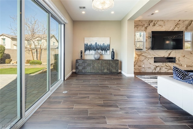 interior space featuring wood tiled floor, visible vents, baseboards, and recessed lighting