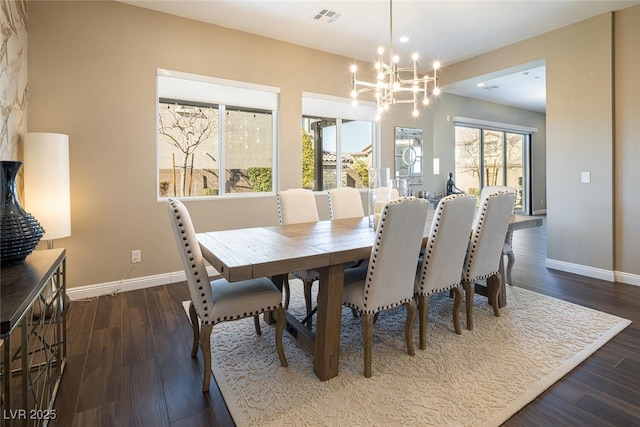 dining room featuring an inviting chandelier, baseboards, visible vents, and wood finished floors