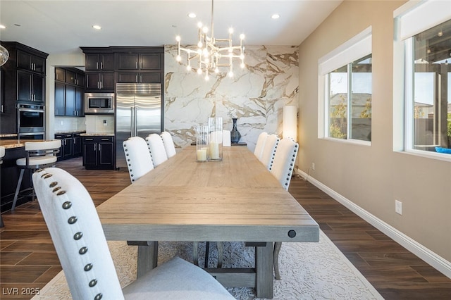 dining area with a chandelier, recessed lighting, dark wood finished floors, and baseboards