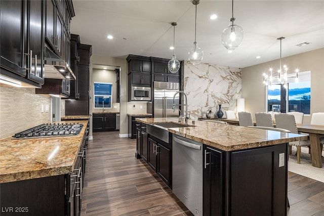 kitchen featuring built in appliances, dark cabinets, visible vents, backsplash, and dark wood-style floors