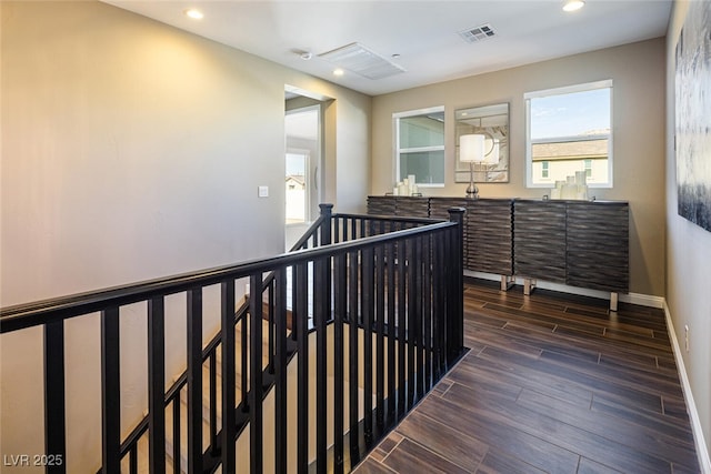 corridor featuring recessed lighting, wood finish floors, an upstairs landing, visible vents, and baseboards