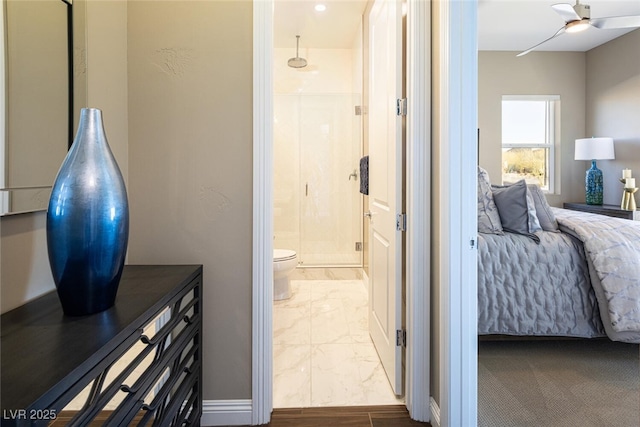 full bathroom featuring a stall shower, marble finish floor, ceiling fan, and toilet