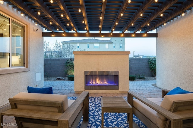 view of patio / terrace featuring an outdoor living space with a fireplace and a fenced backyard