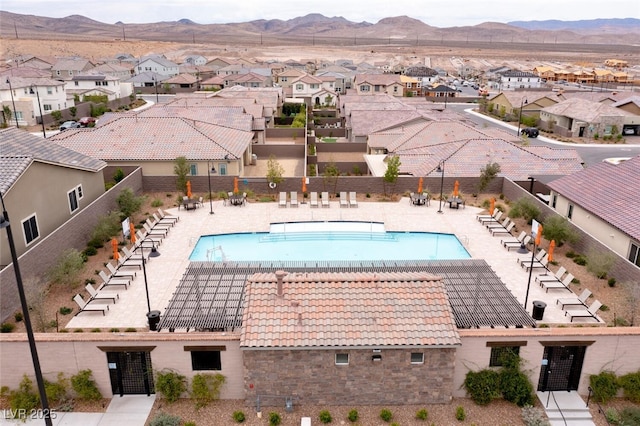 pool featuring a residential view, a patio area, fence, and a mountain view