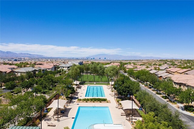 view of swimming pool featuring a residential view, a mountain view, and fence