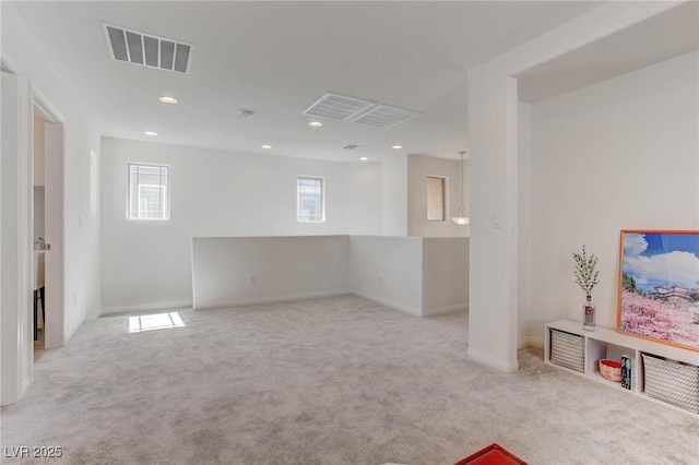 spare room featuring plenty of natural light and light colored carpet