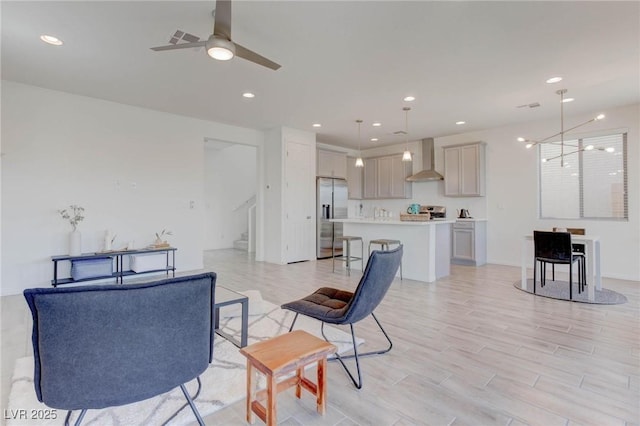 living room with ceiling fan and light hardwood / wood-style floors