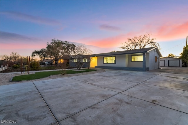 view of front of property with an outbuilding, a detached garage, and stucco siding