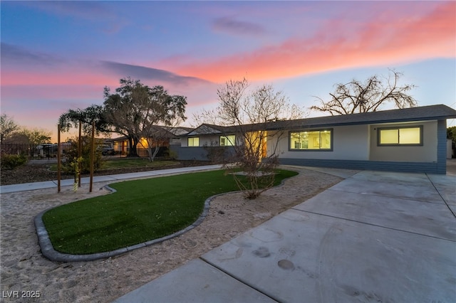 view of front of home featuring a lawn and stucco siding