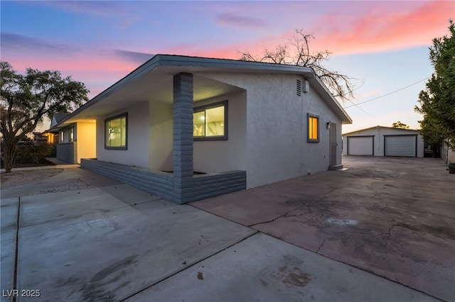 view of home's exterior featuring an outbuilding, a garage, and stucco siding