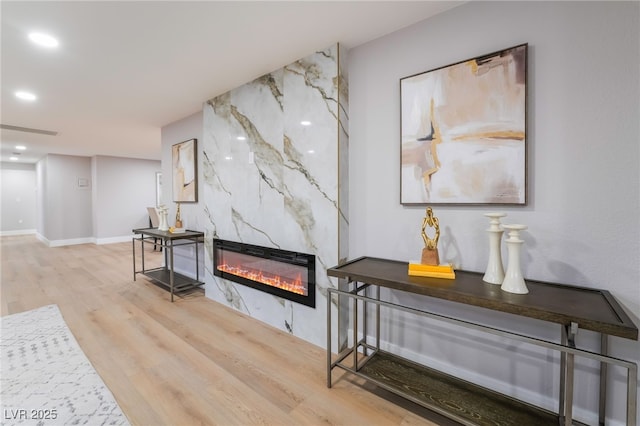 interior space with a fireplace, recessed lighting, visible vents, light wood-style flooring, and baseboards