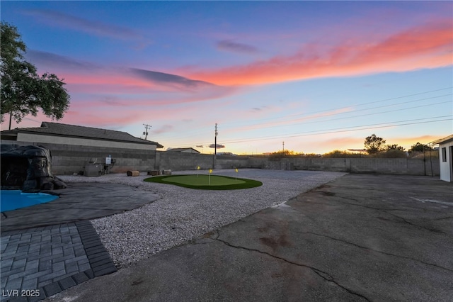 yard at dusk with a patio and a fenced backyard