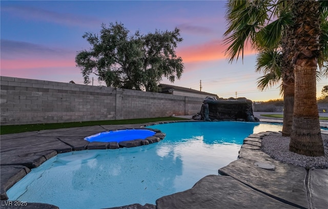 view of pool featuring a pool with connected hot tub and a fenced backyard