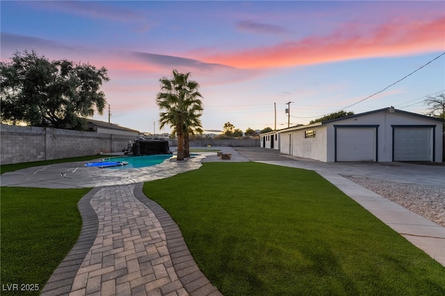 yard at dusk featuring a garage, an outdoor structure, a fenced backyard, and a fenced in pool