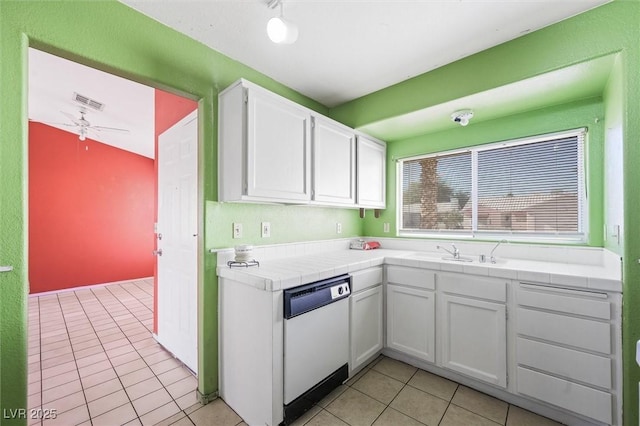 kitchen featuring sink, tile countertops, dishwasher, and white cabinets