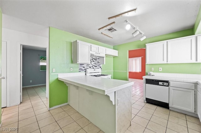 kitchen with tile countertops, white cabinets, light tile patterned floors, kitchen peninsula, and white appliances