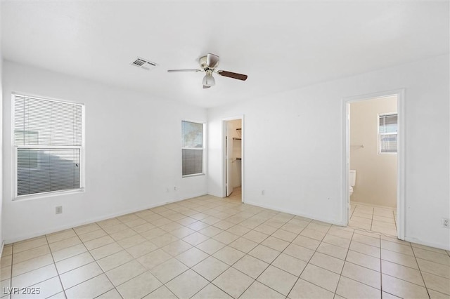 tiled spare room featuring plenty of natural light and ceiling fan