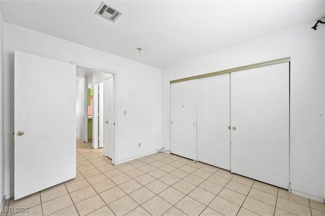 unfurnished bedroom with light tile patterned floors and a closet