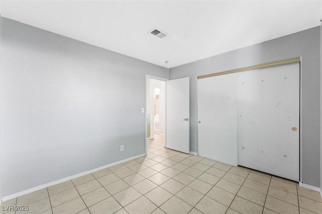 unfurnished bedroom featuring a closet and light tile patterned flooring