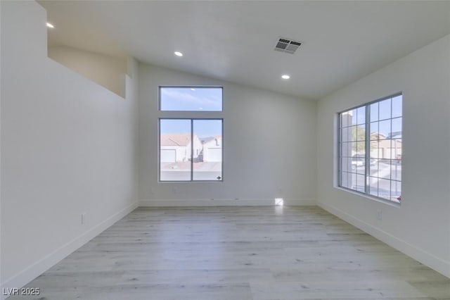 spare room with lofted ceiling and light hardwood / wood-style floors