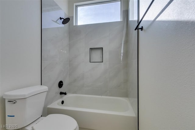 bathroom with toilet and tiled shower / bath combo