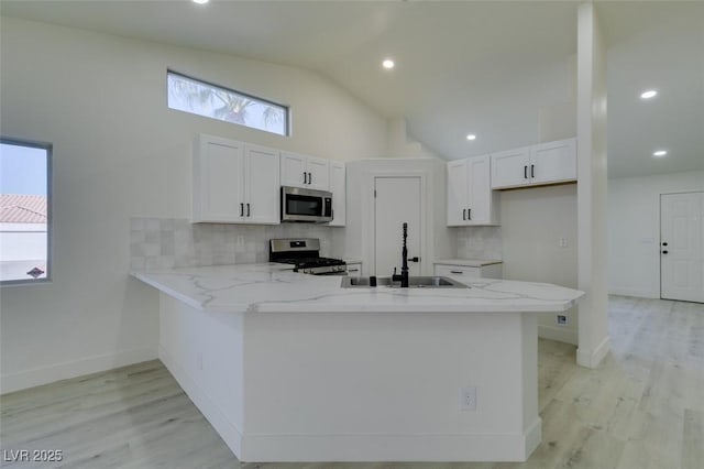 kitchen featuring white cabinetry, appliances with stainless steel finishes, sink, and kitchen peninsula