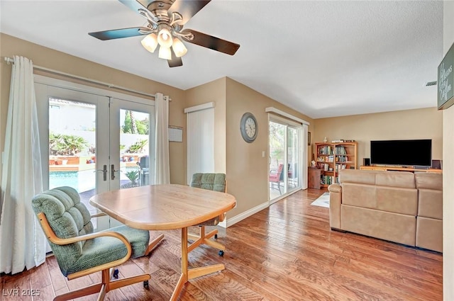 dining space with french doors, plenty of natural light, and light hardwood / wood-style flooring