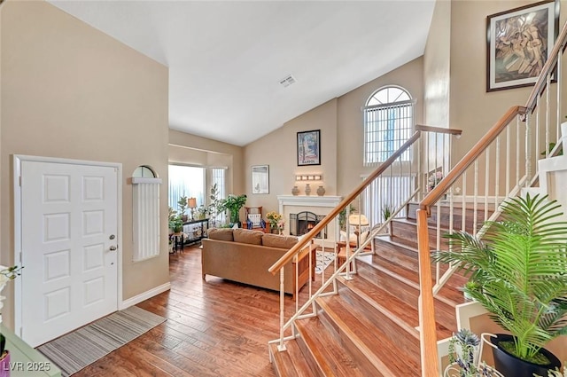 living room featuring wood-type flooring and high vaulted ceiling