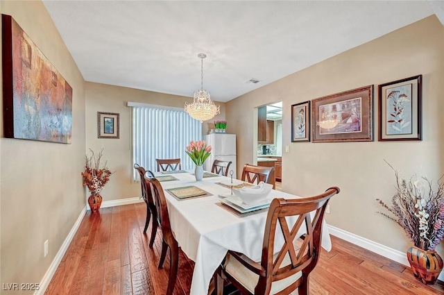 dining area featuring a chandelier and light wood-type flooring