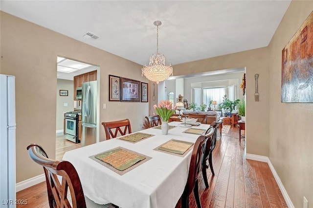 dining room featuring an inviting chandelier and light wood-type flooring