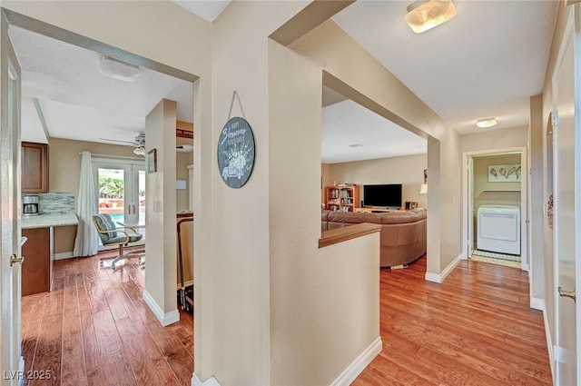 corridor featuring washer / clothes dryer and light hardwood / wood-style floors