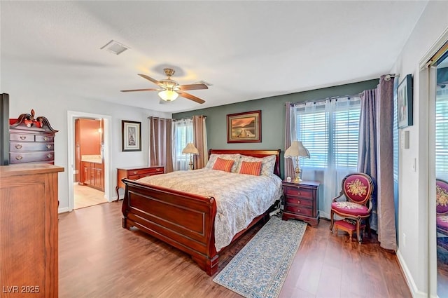 bedroom with ensuite bath, ceiling fan, and light hardwood / wood-style flooring