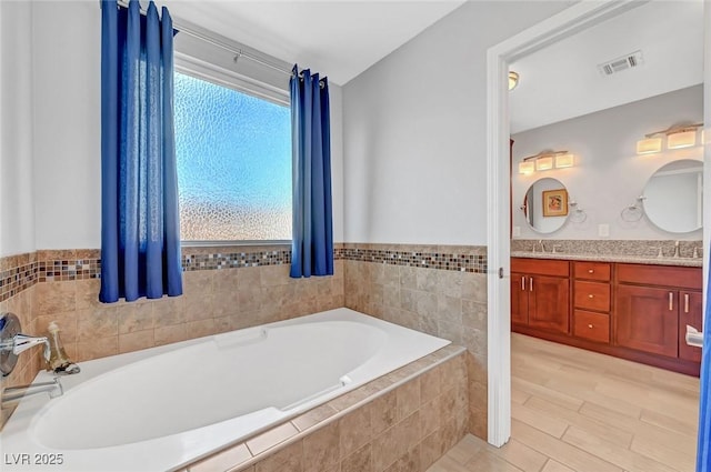 bathroom with vanity, hardwood / wood-style floors, and tiled tub