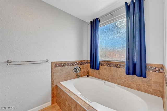 bathroom featuring tile patterned flooring and a relaxing tiled tub