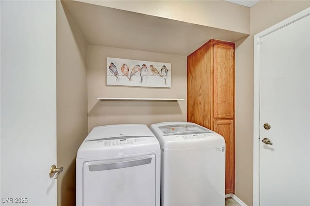 clothes washing area featuring cabinets and washing machine and clothes dryer