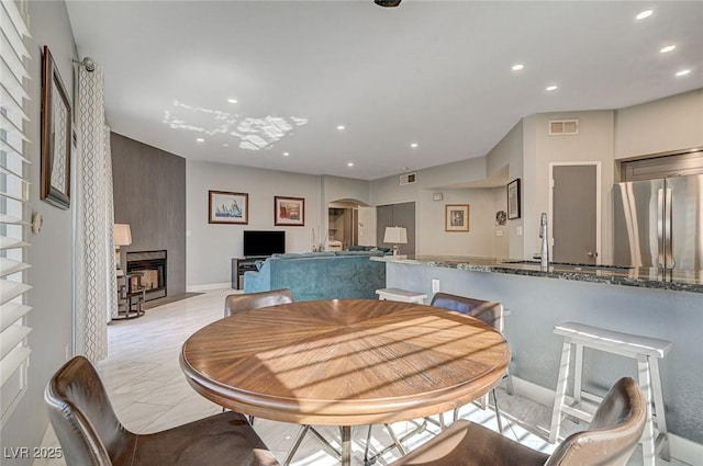 dining area featuring sink and a fireplace