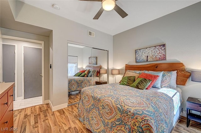 bedroom with light hardwood / wood-style flooring, a closet, and ceiling fan