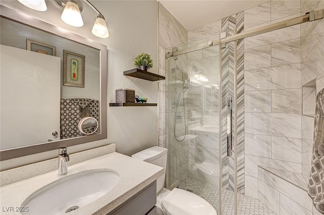 bathroom featuring vanity, a shower with door, and toilet