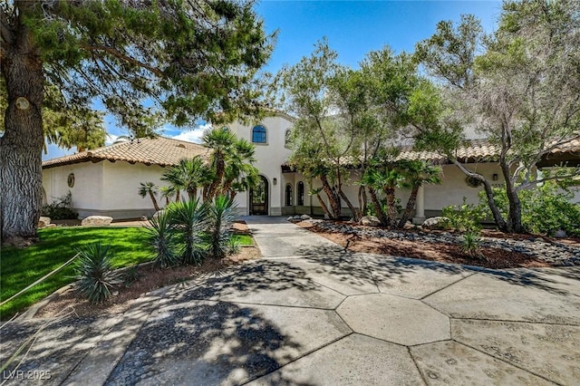 mediterranean / spanish home with a front lawn