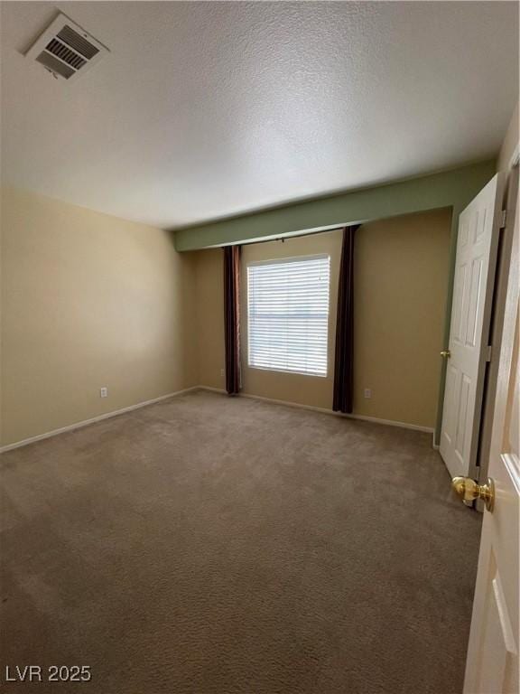 carpeted spare room featuring a textured ceiling