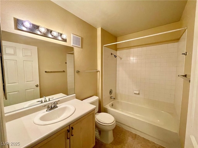 full bathroom featuring vanity, toilet, tiled shower / bath combo, and tile patterned flooring