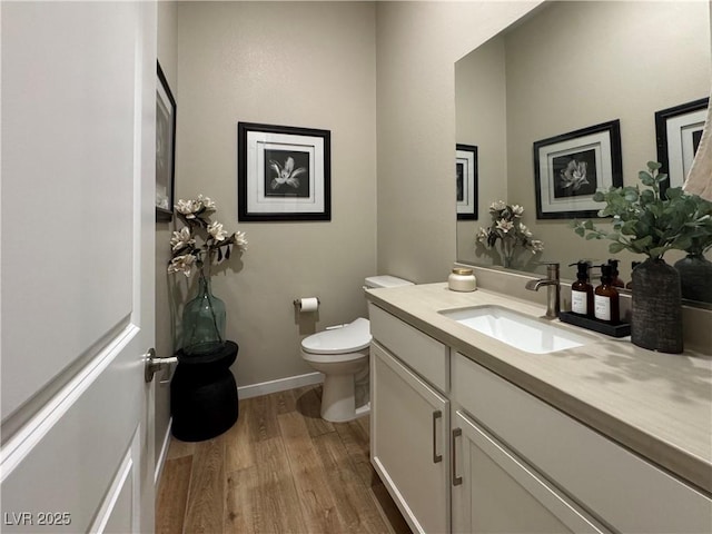 bathroom featuring vanity, hardwood / wood-style floors, and toilet