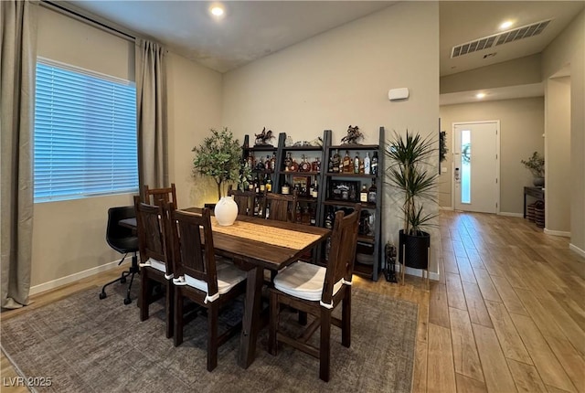 dining room featuring wood-type flooring and lofted ceiling