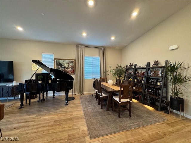 dining space featuring lofted ceiling and light hardwood / wood-style floors