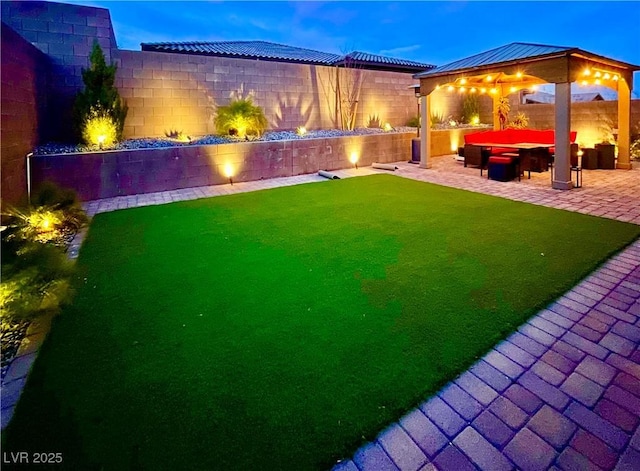 yard at dusk featuring a gazebo and a patio